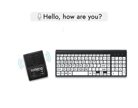 A black keyboard with large white keys and bold black lettering, designed for improved visibility, sits beside a black speaker labeled “talking.” Blue sound waves suggest the speaker is active. Above them, a speech bubble reads, “Hello, how are you?” indicating speech output from the keyboard input.